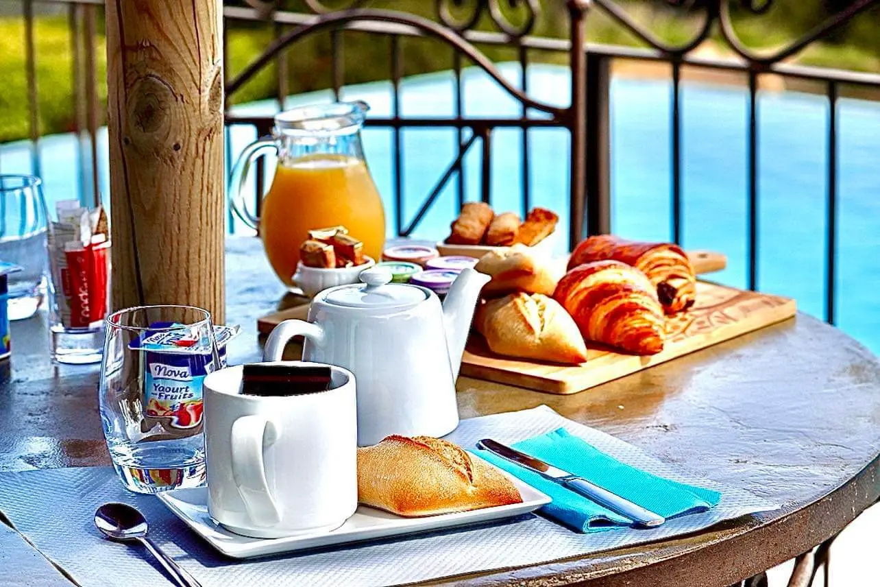 Petit déjeuner en terrasse au bord de la piscine